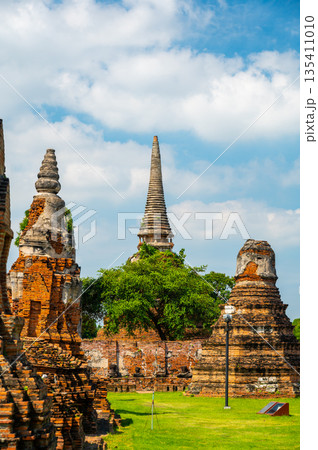 Ruins of ancient city and temples Ayutthaya, Thailand. Old kingdom of Siam. Summer day with blue sky. Famous tourist destination, spiritual place near Bangkok. 135411010