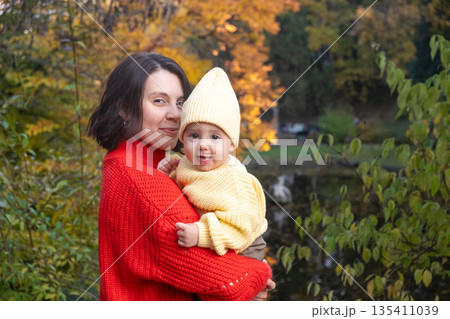 Mother and Baby Smiling in Autumn Park 135411039