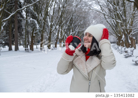 Woman Enjoying Coffee in Snowy Winter Park Woman Enjoying Coffee in Snowy Winter Park 135411082