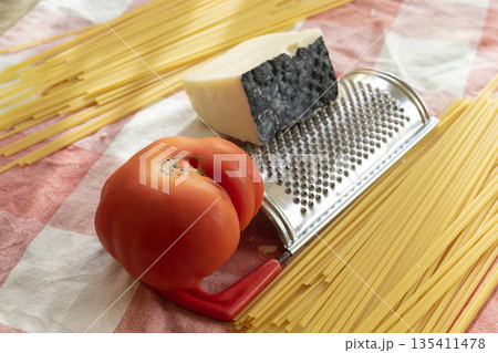 ingredients spaghetti to prepare with pecorino romano and a big tomato ingredients spaghetti to prepare with pecorino romano and a big tomato 135411478