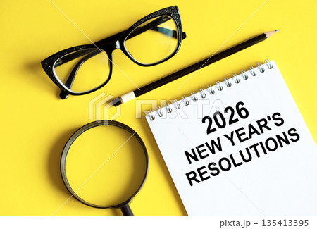 Business and finance concept - notebook with pencils glasses magnifier Business and finance concept - notebook with pencils glasses magnifier 135413395