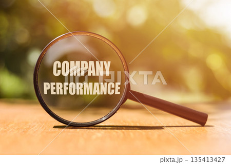 Magnifier glass with text Company Perfomance on wooden table in sunlight. Analysis Growth Progress Business Concept 135413427