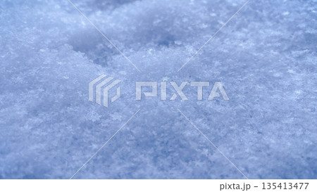 Detailed macro shot of fresh crystalline snow surface with soft blue shadows and sparkling texture Detailed macro shot of fresh crystalline snow surface with soft blue shadows and sparkling texture 135413477