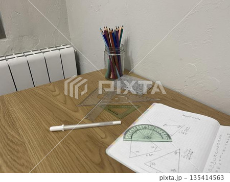 School supplies on a student's desk. Notebooks with homework and geometry tools. School supplies on a student's desk. Notebooks with homework and geometry tools. 135414563