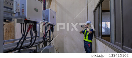 Inspector examination of photovoltaic modules using a thermal imaging camera. 135415102