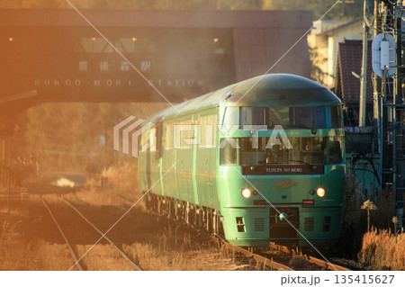 夕日を浴びながら豊後森駅を出発する特急「ゆふいんの森」（JR九州） 135415627