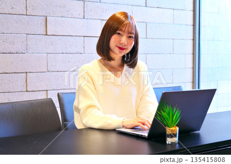 オフィスのデスクでノートパソコンを使っている女性 135415808