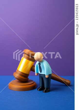 A dejected office worker and a judge's gavel. The infringement of workers' rights, the deterioration of working conditions and increased control by businesses. Labor law pressure, compliance conflicts 135415913
