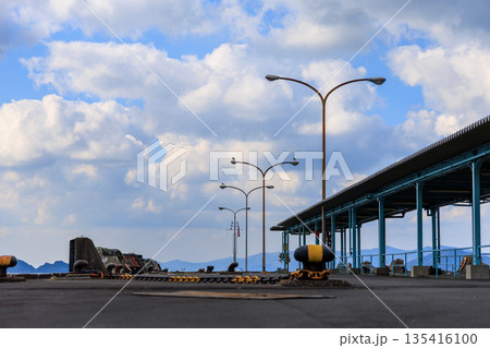 愛媛県八幡浜港の広角波止場 街灯と青空 山遠景の港湾空き風景 135416100