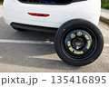 a temporary spare wheel resting on the car, ready to be changed 135416895