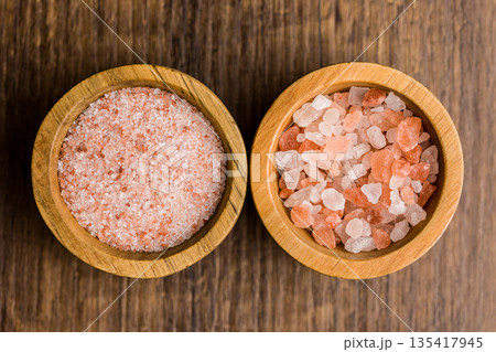 Pink Himalayan salt in bowl on wooden table. Top view. 135417945