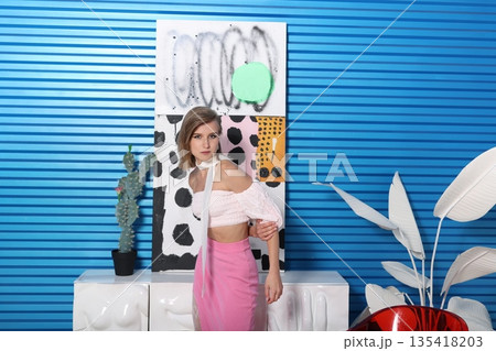 Female model wearing pink near blue textured wall Female model wearing pink near blue textured wall 135418203