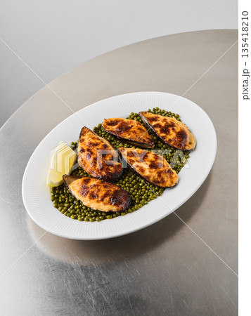 Delicious baked shellfish presented on rustic coastal dish 135418210
