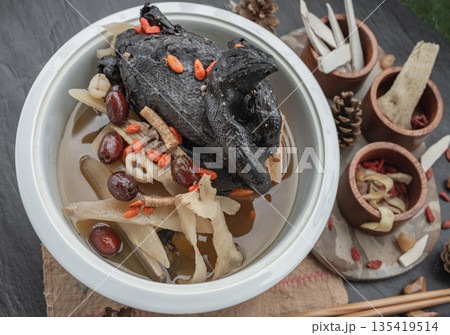 A revered staple in Chinese and Asian culinary traditions, the nourishing health stew pictured is widely celebrated as "Black Chicken Soup" also known as Stewed Black Bone Chicken or silkie chicken 135419514