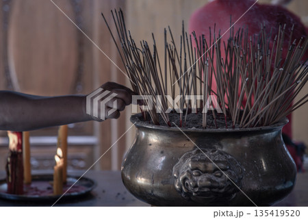 Incense burning at a temple in Wat Mangkon Kamalawat, Bangkok. Incense burning at a temple in Wat Mangkon Kamalawat, Bangkok. 135419520