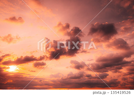 Sunset Cloudy Sky With Fluffy Clouds. Sunset Sky Natural Background. Sunrays In Dramatic Sky. Sunset In Yellow, Orange, Pink Colors Sunset Cloudy Sky With Fluffy Clouds. Sunset Sky Natural Background. Sunrays In Dramatic Sky. Sunset In Yellow, Orange, Pink Colors 135419526