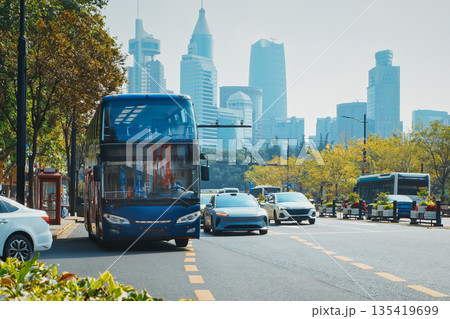 Public bus in motion against a backdrop of tall skyscrapers and blue skies. Shanghai, China 135419699