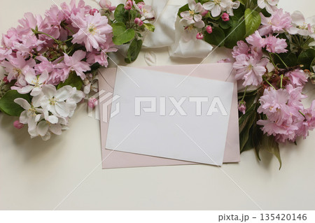 Blank paper greeting card, pink envelope, surrounded by Japanese cherry blossoms, apple flowers, silk ribbon. Beuatiful floral mockup for wedding invitations, stationery, greetings, or spring messages Blank paper greeting card, pink envelope, surrounded by Japanese cherry blossoms, apple flowers, silk ribbon. Beuatiful floral mockup for wedding invitations, stationery, greetings, or spring messages 135420146