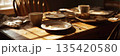 The table shows two empty cups and a plate with crumbs. There is also a stack of bread on a plate in a kitchen with morning light shining through the window, banner 135420580