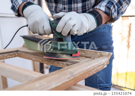 Carpenter at work, restoring an old wooden window. Carpentry. Carpenter at work, restoring an old wooden window. Carpentry. 135421074