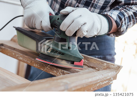 Carpenter at work, restoring an old wooden window. Carpentry. Carpenter at work, restoring an old wooden window. Carpentry. 135421075