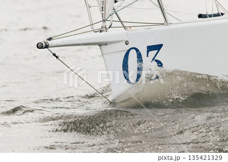 bow of a sailing boat with bowsprit at sailing regatta in the Gulf of Finland at sunny day, sailing yacht competing in a race, splashing water from under the boat, teamwork, board the boat 135421329
