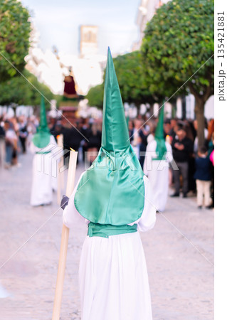 Nazarene walking in a holy week procession in Andalusia Spain holding a silver cross. Nazarene walking in a holy week procession in Andalusia Spain holding a silver cross. 135421881