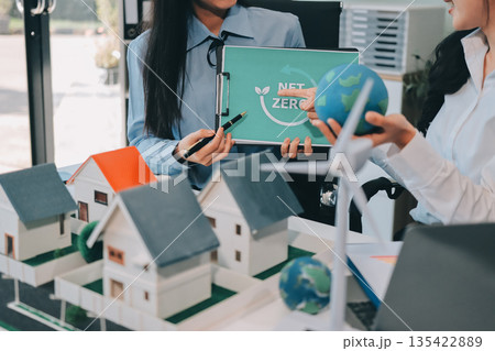 Hands of adult Asian business professionals analyzing ESG financial data and renewable energy project plans 135422889
