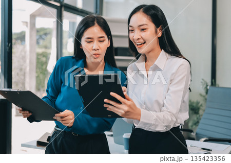 Businesswomen having discussion in office Businesswomen having discussion in office 135423356