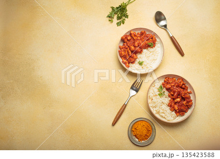 Indian chicken curry with rice and turmeric on yellow background with copy space top view Indian chicken curry with rice and turmeric on yellow background with copy space top view 135423588