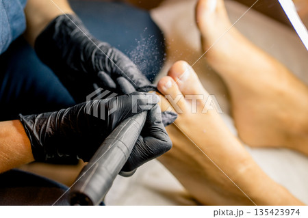 View of the process of a pedicure performed by a master. View of the process of a pedicure performed by a master. 135423974
