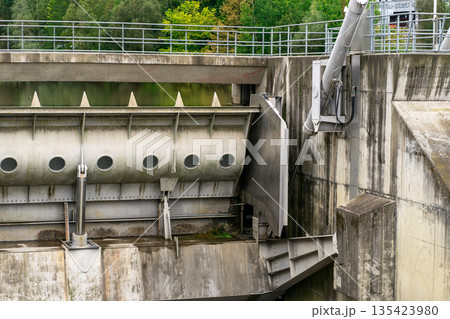 View of a closed spillway on a small dam on a river. View of a closed spillway on a small dam on a river. 135423980