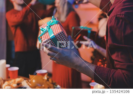 Festive Office Christmas Party with Delicious Food. A beautifully decorated office space with Christmas trees and festive lights, set up for a holiday party. 135424106