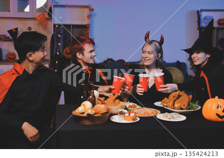 Friends enjoying a Halloween party at a bar making a toast Friends enjoying a Halloween party at a bar making a toast 135424213