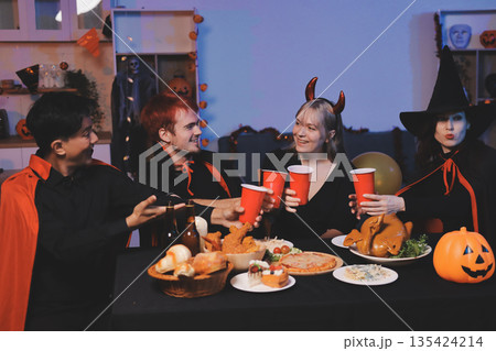 Friends enjoying a Halloween party at a bar making a toast Friends enjoying a Halloween party at a bar making a toast 135424214