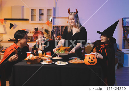 Friends enjoying a Halloween party at a bar making a toast 135424220