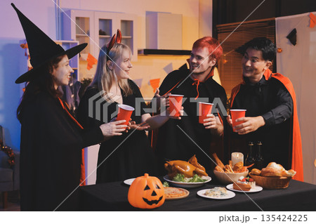 Friends enjoying a Halloween party at a bar making a toast Friends enjoying a Halloween party at a bar making a toast 135424225