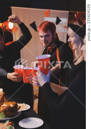 Friends enjoying a Halloween party at a bar making a toast Friends enjoying a Halloween party at a bar making a toast 135424229