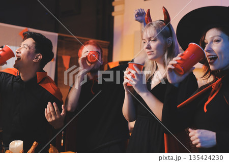 Friends enjoying a Halloween party at a bar making a toast 135424230