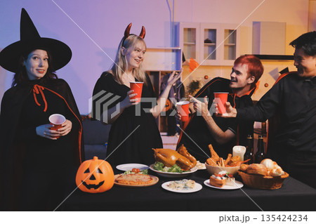 Friends enjoying a Halloween party at a bar making a toast 135424234