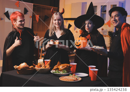 Friends enjoying a Halloween party at a bar making a toast 135424238