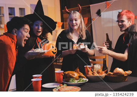 Friends enjoying a Halloween party at a bar making a toast Friends enjoying a Halloween party at a bar making a toast 135424239