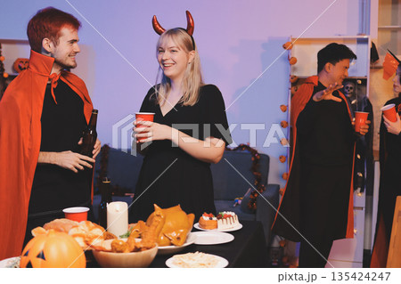 Friends enjoying a Halloween party at a bar making a toast 135424247