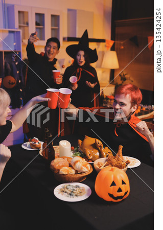 Friends enjoying a Halloween party at a bar making a toast 135424254