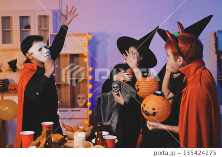 Friends enjoying a Halloween party at a bar making a toast Friends enjoying a Halloween party at a bar making a toast 135424275