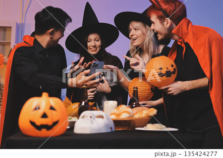 Friends enjoying a Halloween party at a bar making a toast 135424277