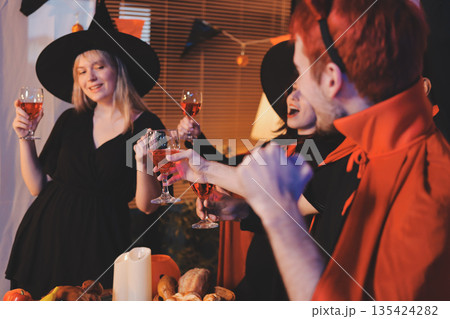 Friends enjoying a Halloween party at a bar making a toast Friends enjoying a Halloween party at a bar making a toast 135424282