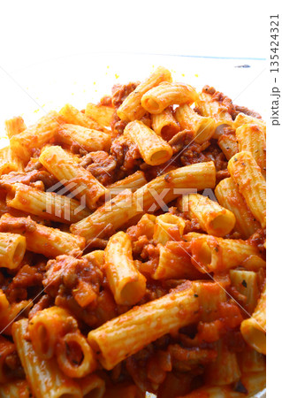 Classic macaroni bolognese with tomato meat sauce and grated cheese topping. 135424321