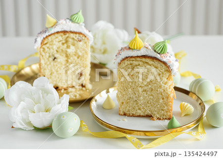 Cutted Easter Cake Decorated Yellow Ribbon with Flowers and Pastel Eggs on White Background Cutted Easter Cake Decorated Yellow Ribbon with Flowers and Pastel Eggs on White Background 135424497