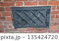 Old metal hatch in brick wall 135424720